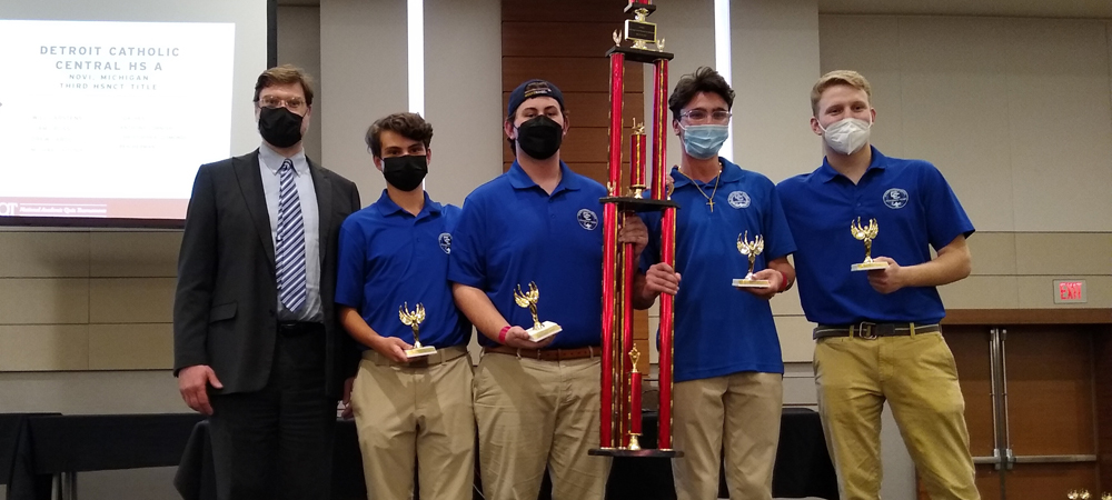 Detroit Catholic Central High School's A team with their first-place trophy from the 2022 High School National Championship Tournament